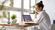 Female employee taking notes from a laptop at a desk