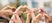 Multiple hands reaching up in a heart shape