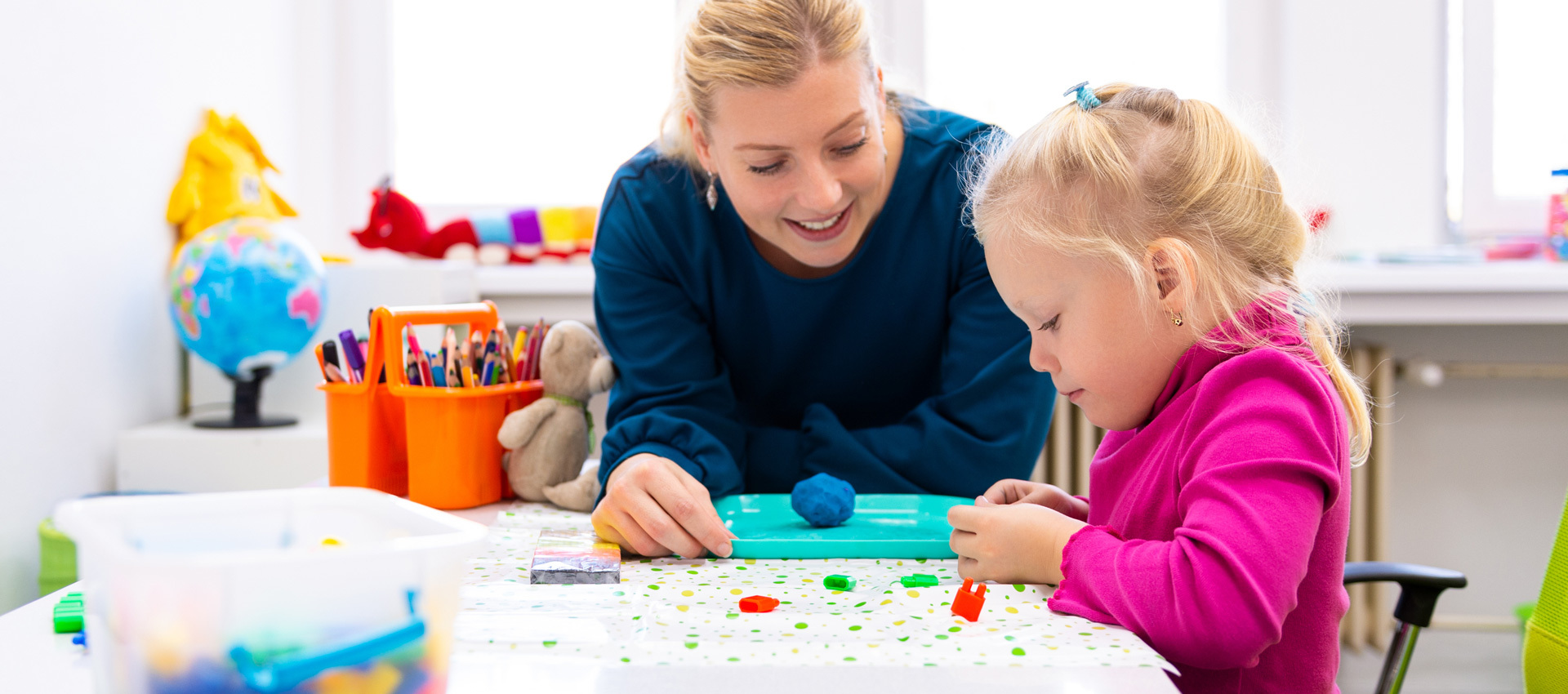 Educator working with a preschooler girl in her home
