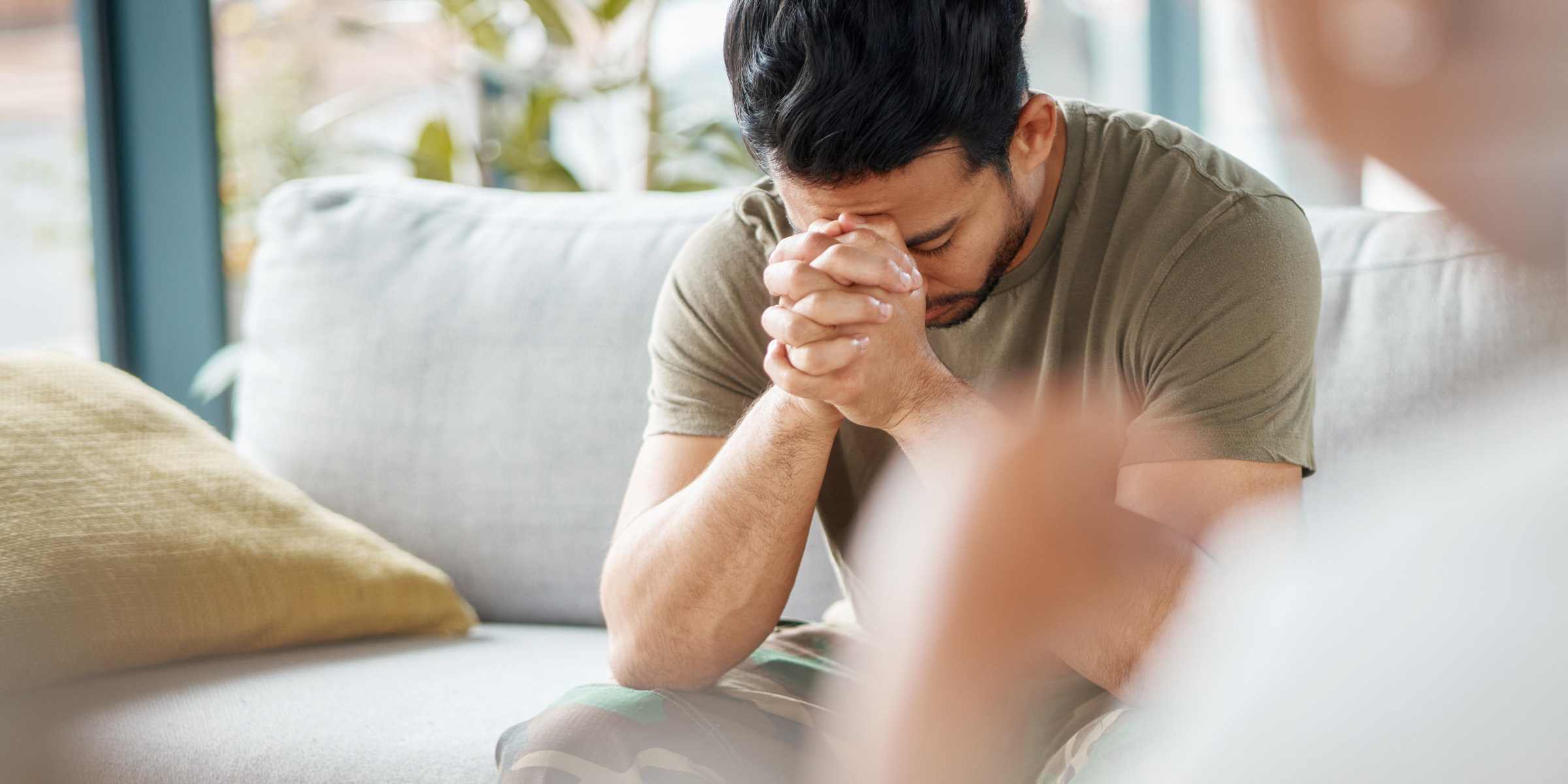 Adult man resting his head on crossed hands during counseling session